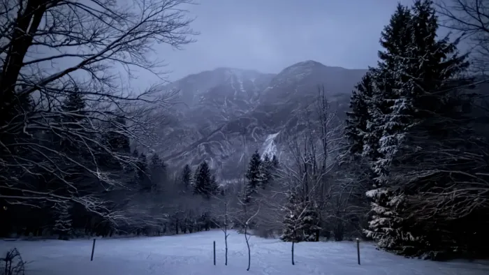 Snow-covered valley floor near Lake Bohinj with the mountains beyond
